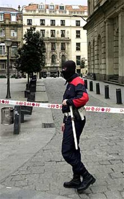 Un agente de la Ertzaintza patrulla en las inmediaciones de la Bolsa de Bilbao.