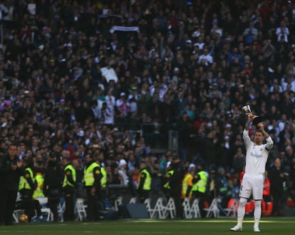 El capitán del Real Madrid, Sergio Ramos, muestra al público el trofeo del Mundial de Clubes 2017 de la FIFA que conquistaron la pasada semana en Abu Dabi, al inicio del partido de la jornada 17 de Liga en Primera División que el Real Madrid y el Barcelona disputan hoy en el estadio Santiago Bernabeu