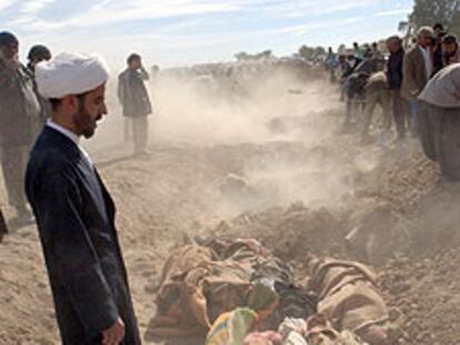 Un clérigo iraní reza ante varios cadáveres en Bam.