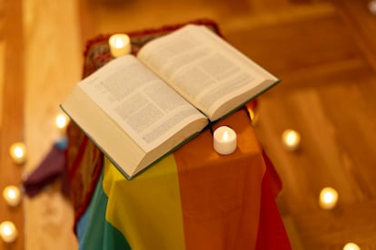 Una Biblia sobre la bandera arcoíris durante la oración LGTBIQ+.