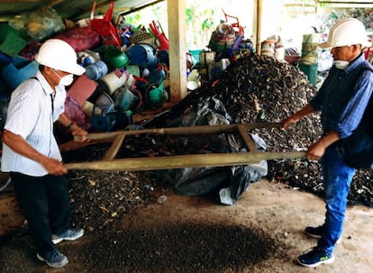 Hombres representando el proceso de compostaje en el área de reciclaje del vertedero público de Nauta, Perú.