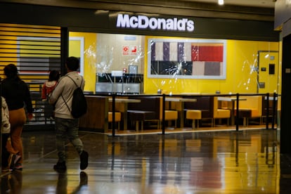 Dos personas pasan delante del McDonald's donde ocurrió el suceso, en el centro comercial Màgic Badalona, el 27 de marzo.
