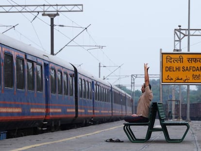 Un empleado del lujoso tren Rajasthan On Wheels huye del ruido en una estación secundaria de Nueva Delhi.