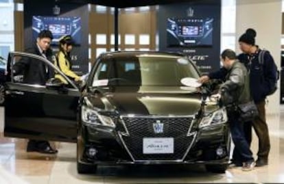 Varias personas inspeccionan el último vehículo de la serie de lujo de la compañía japonesa Toyota Motor, el nuevo Crown Athlete, en un concesionario de Tokio, en Japón. EFE/Archivo