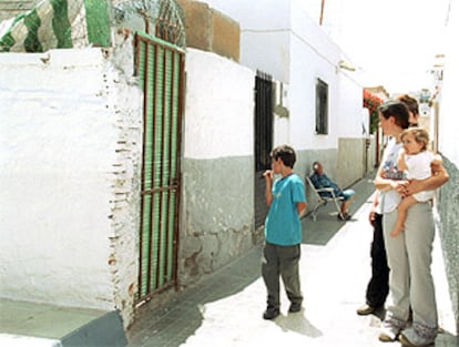 Vecinos del barrio de El Puche de Almeria frente a la casa donde un hombre ha matado a su esposa de varias cuchilladas.