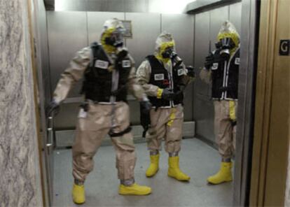 Policías con trajes contra agentes bioquímicos entran en uno de los edificios del Capitolio.