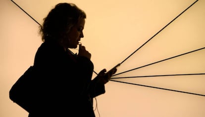 Una mujer usa un tel&eacute;fono m&oacute;vil durante el Mobile World Congress.
