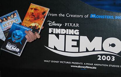 DVD ilegales en Madrid ante el cartel de <i>Buscando a Nemo</i>.