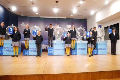 Los niños de San Ildefonso muestran el 37142, agraciado con el primer premio.