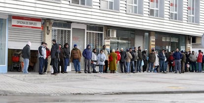 Varias personas forman una larga cola ante una oficina del INEM, foto de archivo. 