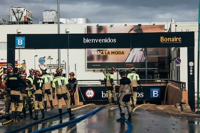 Un equipo de bomberos achican agua del parking del centro comercial Bonaire en Aldaia, este domingo.