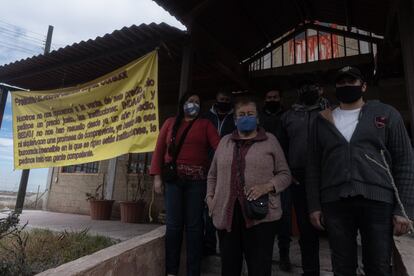 La familia Martínez Gómez posa en la puerta de su restaurante junto a un reclamo que pide "un precio justo" por su terreno.