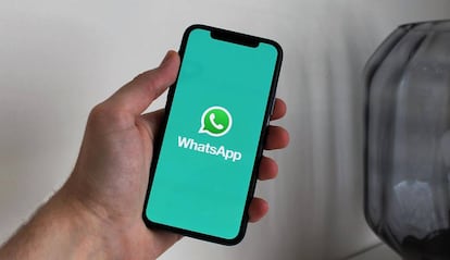 Teléfono con la app WhatsApp y fondo verde