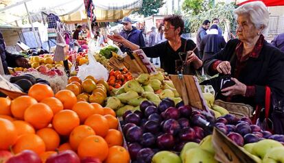 Una mujer compra la fruta en un mercado orgánico.