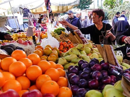 Una mujer compra la fruta en un mercado orgánico.