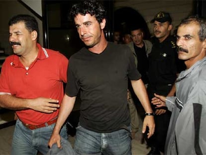 En la imagen, el fotógrafo español es fuertemente custodiado tras su liberación.