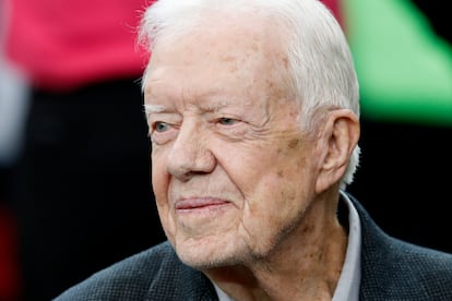 Former President Jimmy Carter sits on the Atlanta Falcons bench before the first half of an NFL football game between the Atlanta Falcons and the San Diego Chargers, Oct. 23, 2016, in Atlanta.