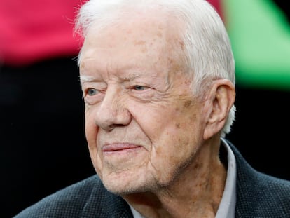 Former President Jimmy Carter sits on the Atlanta Falcons bench before the first half of an NFL football game between the Atlanta Falcons and the San Diego Chargers, Oct. 23, 2016, in Atlanta.