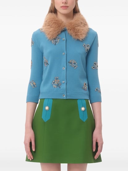 Valentino propone una versión de inspiración 'vintage' de la chaqueta de punto con pedrería. Este diseño no solo lleva unas flores de pedrería bordadas, sino que el color azul pitufo y el cuello de pelo rematan ese espíritu retro irresistible que marcará la diferencia.