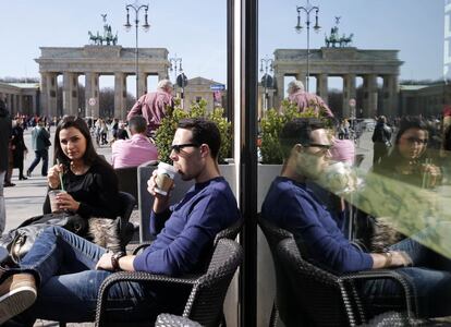 El buen tiempo en Berlín anima a los turistas a tomarse un café en los alrededores de la Puerta de Brandenburgo.