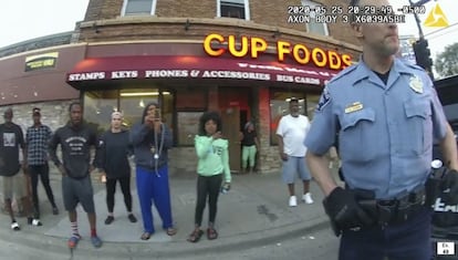 Una captura del vídeo de la cámara del exoficial de policía de Minneapolis, Derek Chauvin. Ahí se muestra al agente fuera de la tienda Cup Foods en Minneapolis, el 25 de mayo de 2020, con una multitud de espectadores detrás de él.