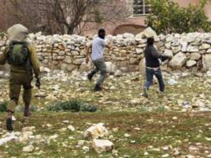 Un soldado israelí persigue a dos manifestantes palestinos durante una protesta contra el asentamiento judío de Qadomem, cerca de la ciudad cisjordana de Nablus. EFE/Archivo