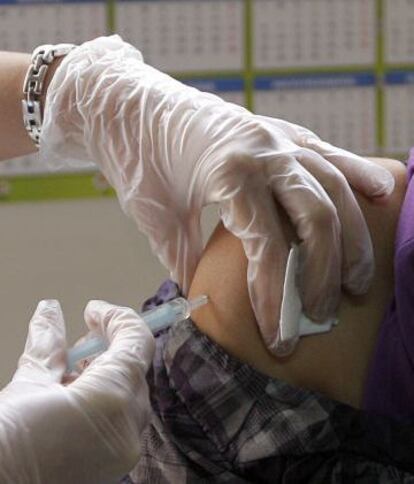 Una enfermera administra una vacuna.