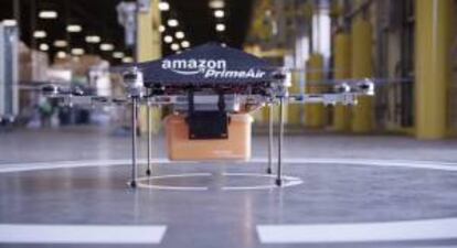 Imagen sin datar cedida por Amazon, que muestra un avión no tripulado o "dron" con una caja de transporte en Seattle, Estados Unidos.