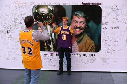 Aficionados de los Lakers se retratan ante un mural con una imagen de Jerry Buss situado junto al Staples Center de Los Ángeles.