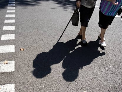 Una pareja de ancianas pasea por una calle de Barcelona en un día de verano.