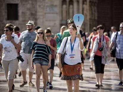 Un grupo de turistas sigue a su gu&iacute;a por el centro hist&oacute;rico de Valencia