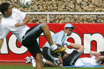 Riquelme se entrena con la pelota mientras Messi hace ejercicios físicos.