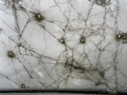 Fotografía tomada desde el asiento del conductor de una furgoneta cubierta de nieve en Lukashivka (Ucrania), que sufrió graves daños durante la invasión rusa en marzo de 2022.