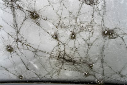 Fotografía tomada desde el asiento del conductor de una furgoneta cubierta de nieve en Lukashivka (Ucrania), que sufrió graves daños durante la invasión rusa en marzo de 2022.