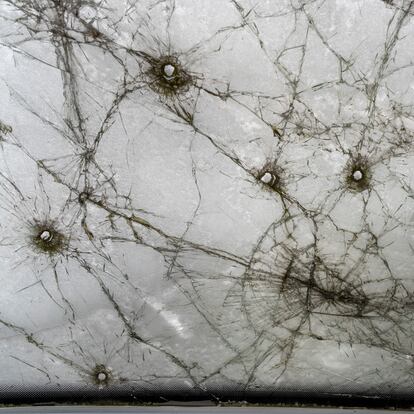 Fotografía tomada desde el asiento del conductor de una furgoneta cubierta de nieve en Lukashivka (Ucrania), que sufrió graves daños durante la invasión rusa en marzo de 2022.