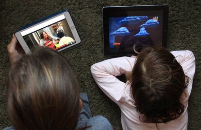 Dos personas ven series de televisión en tabletas.