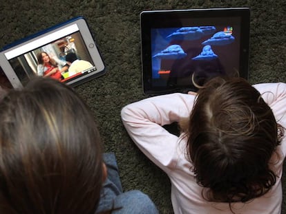 Dos personas ven series de televisión en tabletas.
