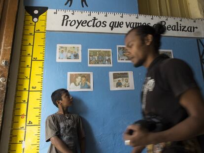 Dos chicos en la entrada del Centro Social donde se exponen los proyectos en los que trabajan.