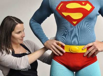 Una empleada de la casa australiana a cargo de subastar el traje de Superman prepara la exhibición de las piezas