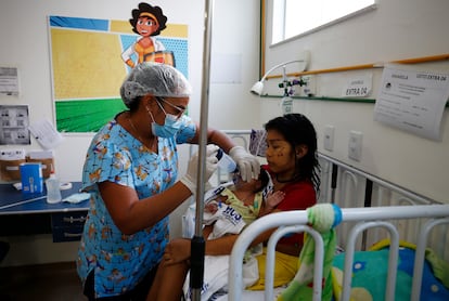 Una trabajadora sanitaria alimenta a un bebé, en el hospital pediátrico Santo Antonio, en Boa Vista.