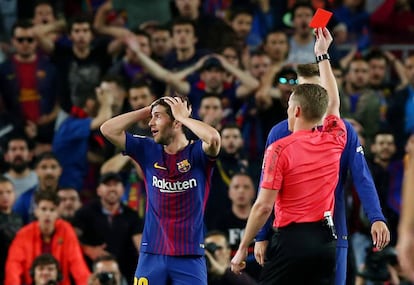 A referee shows a red card to Barcelona's Sergi Roberto.