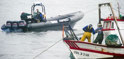 Agentes de la Guardia Civil, junto a un pesquero de la bah&iacute;a de Algeciras.