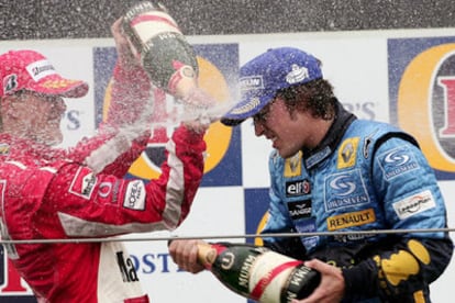 Michael Schumacher y Fernando Alonso se riegan con champaña en el podio.