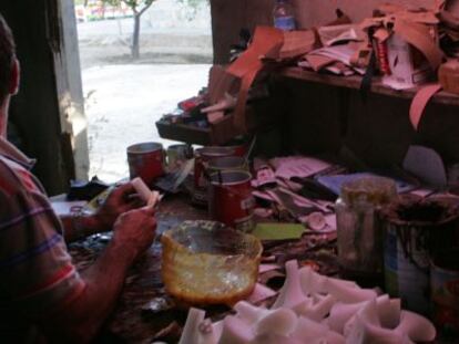 Un trabajador pega tacones en un taller ilegal en su casa. 