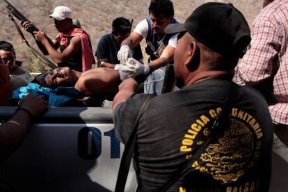 Policías comunitarios auxilian a un hombre herido en Cocula.