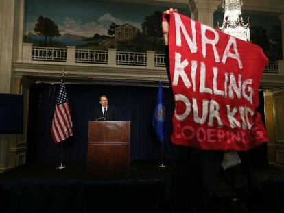 Un hombre protesta durante la rueda de prensa del vicepresidente de la NRA, Wayne Lapierre, en Washington. 