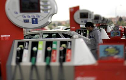 Un joven pone gasolina a su coche en un surtidor de Cepsa.