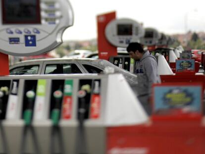 Un joven pone gasolina a su coche en un surtidor de Cepsa.