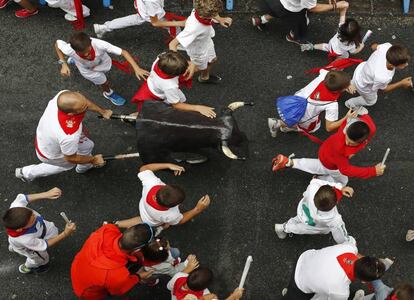 Un grupo de niños corre por delante de un toro de cartón en la Cuesta de Santo Domingo, Pamplona, durante el encierro 'txiki', el 10 de junio de 2017.