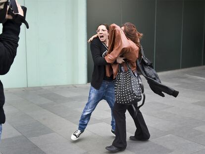 La madre que pegó a la profesora se cubre con una chaqueta al salir del juzgado.